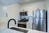 Model kitchen at our apartments for rent in NoMad, NYC, featuring stainless steel appliances and white counters.