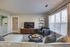 View of furnished living room in a Pembroke MA apartment with wood flooring and a grey sectional sofa.