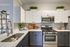 Luxury Mansfield apartment kitchen with white wooden cabinetry and stainless steel appliances.