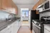 Model kitchen at our apartments in New York, featuring wood grain cabinetry and stainless steel appliances.