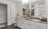 Model bathroom at our apartments in Atlanta, featuring tile flooring, grey countertops, and a view of the walk in closet.