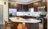 Luxury Denver Colorado apartment kitchen with a kitchen island, dark cabinetry and stainless steel appliances.