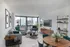 Model living room at our apartments in New York, featuring a large window with a view of the city and a flat screen TV.