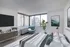 Model bedroom at our apartments near Flatiron, featuring wood grain floor paneling and windows with a view of the city.
