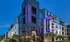 The exterior of the Newbergh ATL apartment complex in Atlanta, featuring a view of the light up sign.