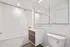 Bathroom with floating sink, large mirrors, and tub
