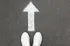 Shoes and an arrow on the ground
