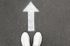 White Colored Arrow with a Person Wearing White Tennis Shoes