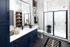 Spa inspired bathroom with glass panel shower doors and navy blue cabinets
