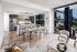 Modern kitchen with an island for entertaining featuring stainless steel appliances and floor-to-ceiling windows featuring a dining area