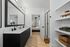 Bathroom with elevated finishes to include quartz counters, oversized mirror, built-in shelving and matte black finishes