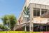 Vibrant street view featuring Modern Margarita restaurant with lush landscaping and sunny outdoor seating.