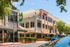 Chic urban complex featuring a vibrant mix of modern restaurants and retail spaces with stylish architecture and abundant greenery.