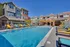 Inviting apartment community showcasing a sunlit pool area with colorful lounge chairs and modern building architecture.