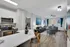 Chic open-concept apartment showcasing a modern kitchen with sleek appliances, a cozy living area with stylish decor, and abundant natural light through large windows.