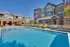 Charming apartment complex featuring a refreshing swimming pool surrounded by colorful lounge chairs and modern architecture.