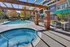 Inviting outdoor space featuring a sparkling pool and relaxing hot tub, surrounded by stylish seating and modern patio umbrellas.
