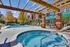 Inviting outdoor pool area with sun loungers, vibrant autumn trees, and stylish pergola, perfect for relaxation and leisure.