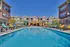Inviting apartment complex with colorful lounge chairs by a sparkling pool, perfect for relaxation and enjoyment.