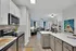 Modern open-plan kitchen and living area with sleek cabinetry, stainless steel appliances, and vibrant decor, offering a stylish and inviting ambiance.