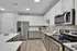 Modern kitchen with sleek stainless steel appliances, elegant white cabinetry, and stylish wood flooring, perfect for culinary enthusiasts.