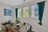 Inviting dining room featuring a modern table set with stylish dishware, vibrant artwork, and natural light filtering through chic green curtains.