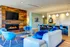 Contemporary living room with vibrant blue accents, cozy fireplace, and stylish open kitchen perfect for entertaining.