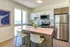 Modern kitchen with sleek stainless steel appliances, spacious island with seating, and large windows offering a stunning ocean view.