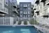Modern apartment complex featuring a refreshing outdoor pool, surrounded by stylish balconies and pristine landscaping.