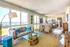 Bright and airy open-plan living room with ocean views, modern kitchen, and stylish decor, perfect for relaxation and enjoying coastal living.