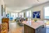 Bright, modern living space with ocean views, stylish white and blue decor, spacious dining area, and wooden accents.