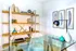Chic home office space with elegant glass desk, modern shelving, and artistic feather wall decor.