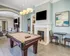 Luxurious entertainment room with elegant pool table, modern fireplace, and stylish seating area.