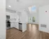 Modern open-concept kitchen with sleek stainless steel appliances, bright skylights, and spacious living area, perfect for stylish urban living.