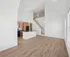 Bright open-concept living area featuring a modern kitchen with sleek appliances and a stylish loft space.