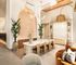 Luxurious modern apartment interior featuring an elegant dining area with a marble table, chic lighting, and contemporary decor, exuding warmth and sophistication.