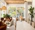 Luxurious and airy living space with plush seating, elegant decor, and abundant natural light streaming through large windows.