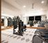 Modern fitness center with state-of-the-art exercise equipment, including treadmills and strength machines, surrounded by mirrors for an open, spacious feel.