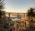 Breathtaking cityscape view from a modern terrace, featuring stylish seating and lush greenery, perfect for sunset relaxation.