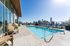 Luxurious rooftop pool with stunning San Diego skyline views, featuring stylish lounge chairs and modern outdoor seating.