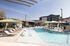 Resort-style pool with lounge chairs and green umbrellas at Sonora in Austin, TX