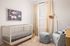 Bedroom styled with a crib, rocking chair and soft decor at Sonora in Austin, TX