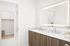 Bathroom with double sinks, wood cabinets and lit mirror at Sonora in Austin, TX