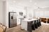 Open kitchen and living room with island and stainless appliances at Sonora in Austin, TX
