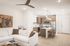 Open living space with white sofa and wood-accented kitchen at Sonora in Austin, TX