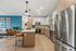 Contemporary kitchen with sleek stainless steel appliances, stylish pendant lighting, and a spacious bar area perfect for entertaining in an open-concept living space.