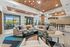 Clubhouse area with contemporary decor, featuring plush seating, stylish lighting, and expansive windows offering scenic views.