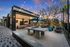 Chic outdoor community space with string lights, modern seating, ping pong table, and vibrant umbrellas under a twilight sky.
