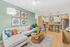 Inviting living room seamlessly connected to a modern kitchen, featuring elegant decor, cozy seating, and warm wood finishes.