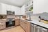 Modern kitchen with sleek cabinets, stainless steel appliances, and elegant marble backsplash, perfect for stylish living.